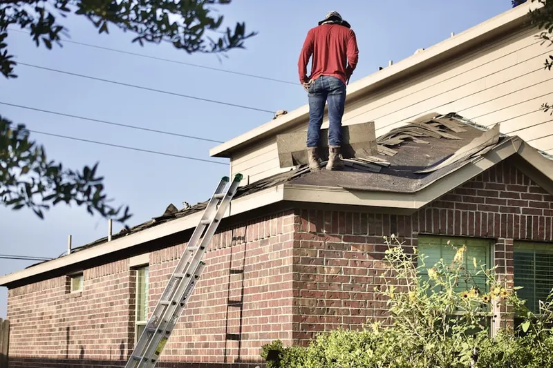 Professional roofer working on a residential roof in Gloucester City